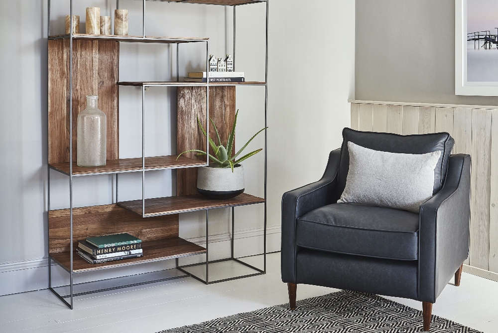 Mid-century modern interiors with small leather armchair and sculptural bookcase for interior design statement 